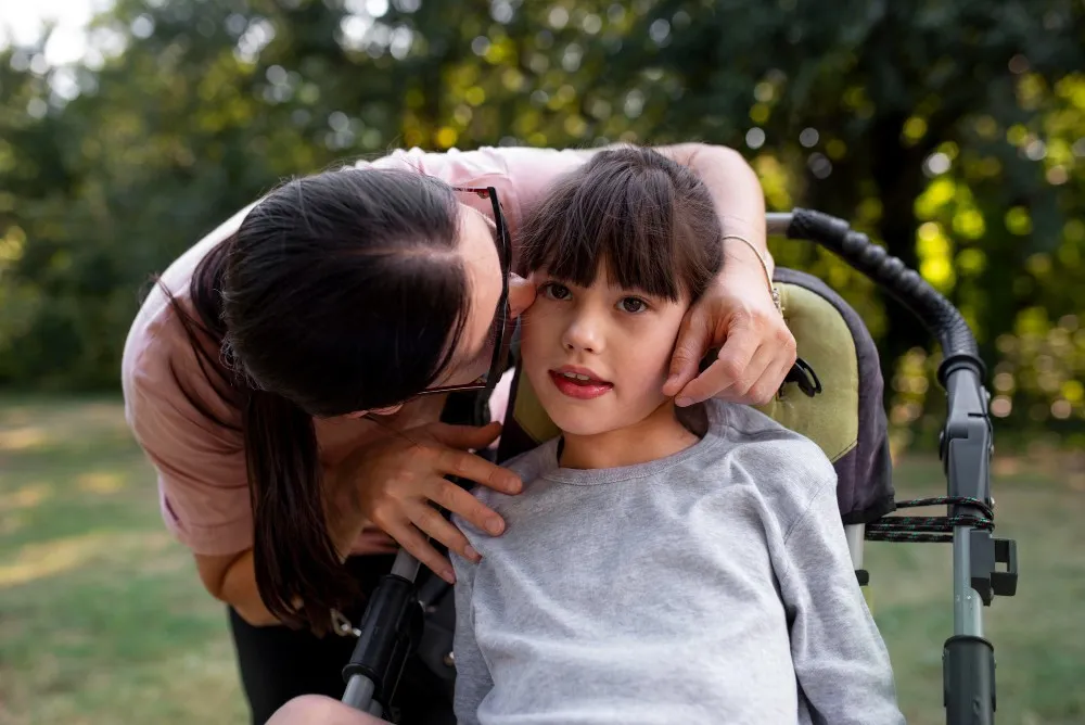 A woman affectionately kisses a little girl in a stroller, highlighting a joyful interaction between them.